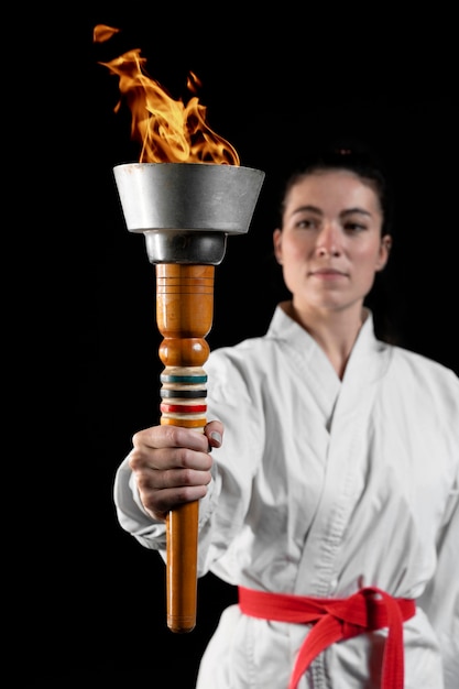 Widok z przodu sportowca karate trzymającego pochodnię