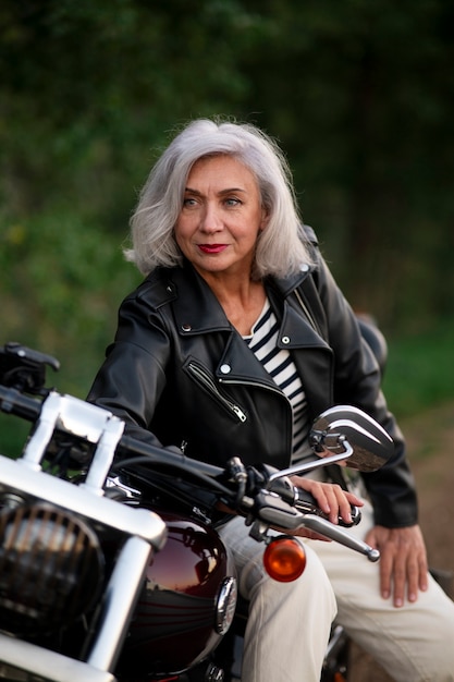 Bezpłatne zdjęcie widok z przodu starsza kobieta z motocyklem