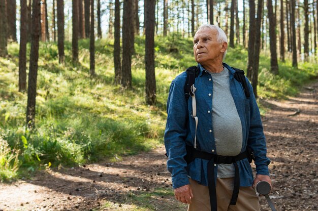 Widok z przodu starszego mężczyzny z plecakiem i odkrywania przyrody