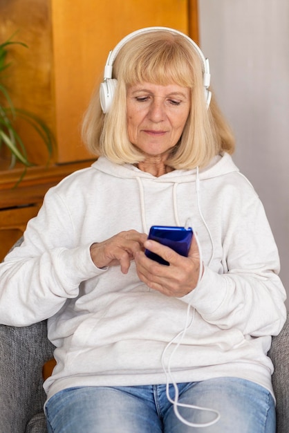 Widok Z Przodu Starszej Kobiety Ze Słuchawkami I Smartfonem
