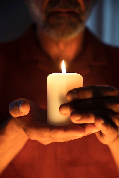 Bezpłatne zdjęcie widok z przodu starszy mężczyzna trzyma świecę