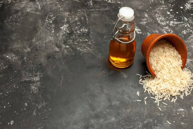 Widok z przodu surowy ryż z olejem na szarej powierzchni olej ryżowy zdjęcie ciemne