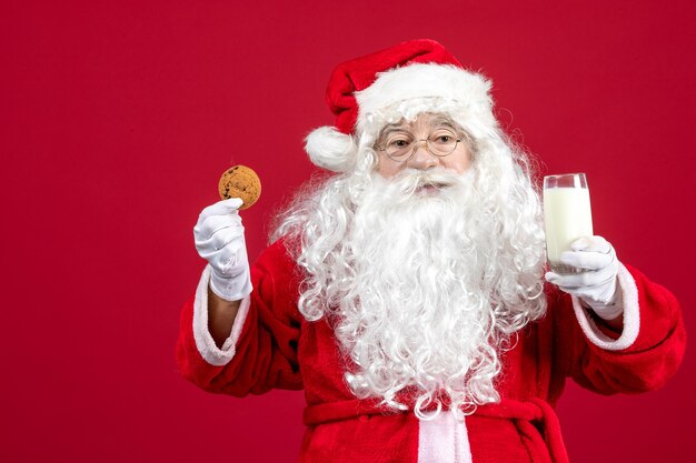 Widok Z Przodu święty Mikołaj Jedzący Ciastka I Pijący Mleko