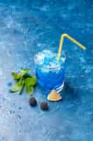 Bezpłatne zdjęcie widok z przodu świeża fajna lemoniada w małym szkle z lodem na niebieskim tle woda zimny sok pić kolor owoców