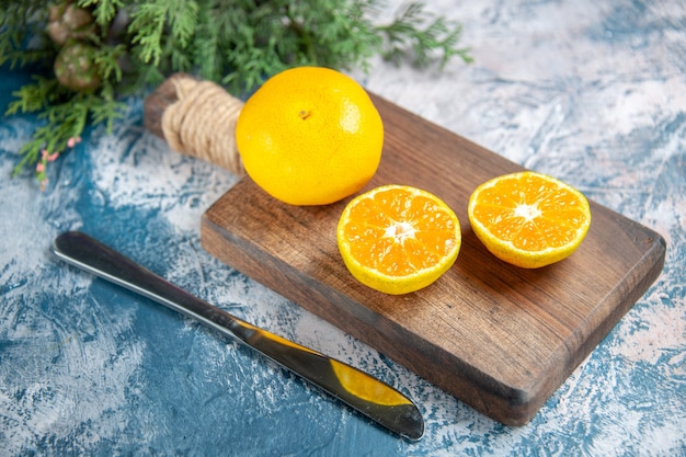Bezpłatne zdjęcie widok z przodu świeża mandarynka na jasnoniebieskim stole sok z cytrusów kolor zdjęcia owoców