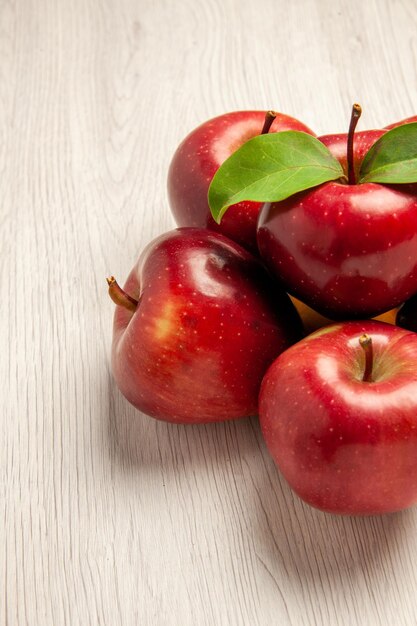 Widok z przodu świeże czerwone jabłka aksamitne i dojrzałe owoce na białym biurku owoce kolor świeża roślina czerwone drzewo