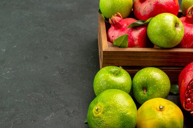 Widok z przodu świeże granaty z mandarynkami i jabłkami na ciemnej powierzchni dojrzałe owoce koloru