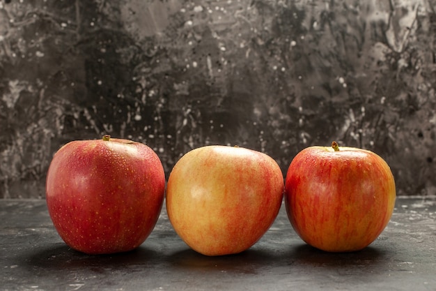 Widok z przodu świeże jabłka wyłożone na ciemnym zdjęciu owoce dojrzałe drzewo witaminowe o łagodnym kolorze soku