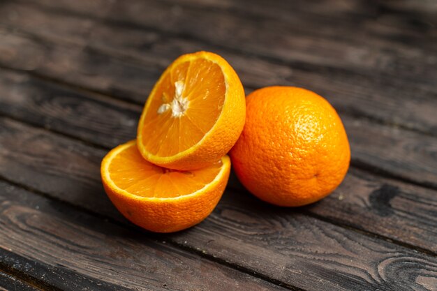 Widok z przodu świeże kwaśne pomarańcze soczyste i łagodne na białym tle na brązowym tle rustykalnym