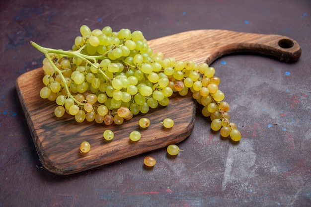 Bezpłatne zdjęcie widok z przodu świeże, łagodne winogrona na ciemnej powierzchni wino świeże owoce winogronowe dojrzałe drzewo