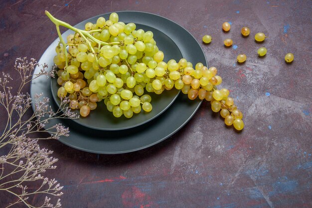 Bezpłatne zdjęcie widok z przodu świeże, łagodne winogrona zielone winogrona na ciemnej powierzchni wino świeże winogrona owoce roślina drzewna dojrzałe