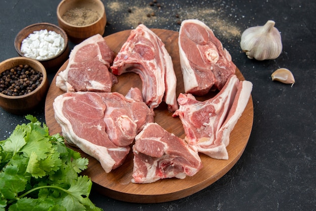 Widok z przodu świeże mięso plastry surowe mięso z przyprawami na szarym tle posiłek świeżość jedzenie krowa jedzenie kuchnia zwierzę