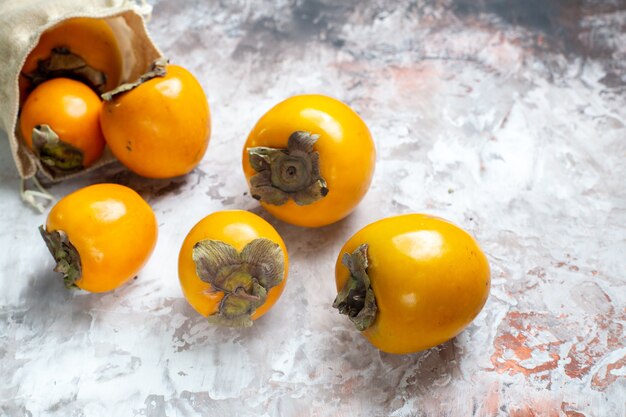 Widok z przodu świeże persimmons na jasnym stole