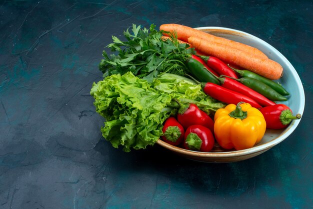 Widok z przodu świeże warzywa z zielenią na niebieskim biurku sałatka z warzywami