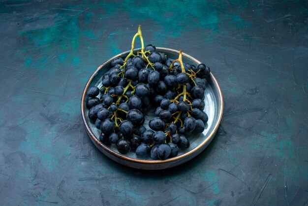 Widok z przodu świeże winogrona czarne winogrona na ciemnym biurku