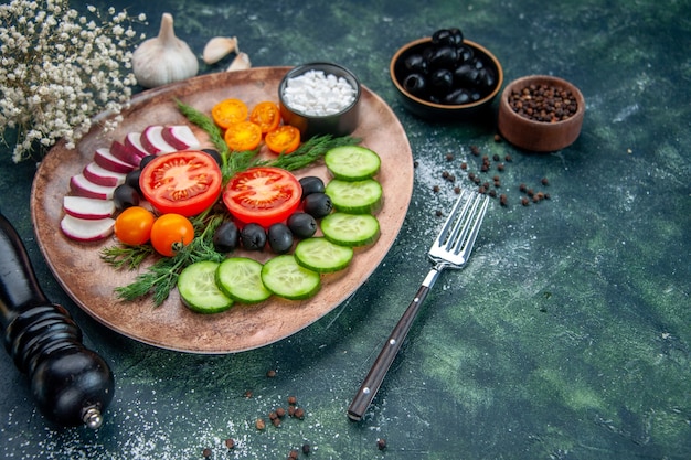 Widok z przodu świeżych posiekanych warzyw oliwki sól w brązowym talerzu i młotek kuchenny czosnek kwiat na zielonym czarnym tle mieszanych kolorów