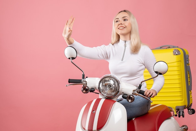 Widok z przodu szczęśliwa młoda dama na motorowerze gestykuluje znak stop