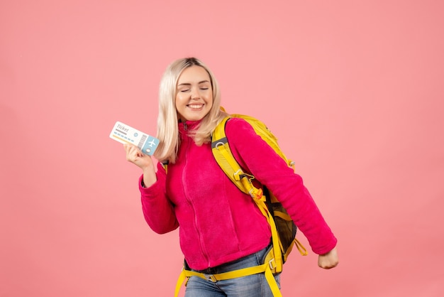 Bezpłatne zdjęcie widok z przodu szczęśliwa podróżniczka kobieta w ubranie na sobie plecak trzymając bilet podróżny