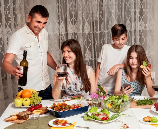 Widok z przodu szczęśliwych rodziców i dzieci przy stole