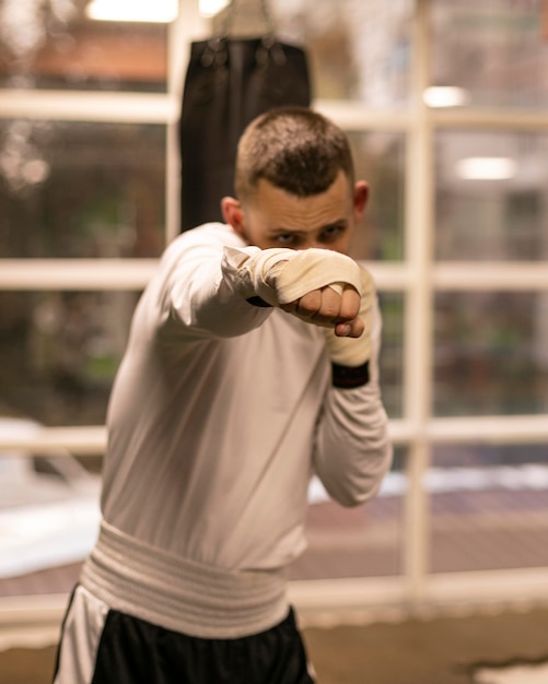 Bezpłatne zdjęcie widok z przodu trenującego boksera z workiem treningowym