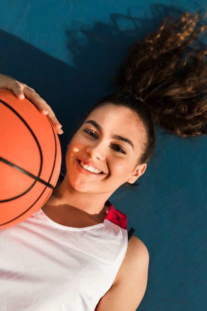 Widok z przodu uśmiechnięta dziewczyna z piłką do koszykówki