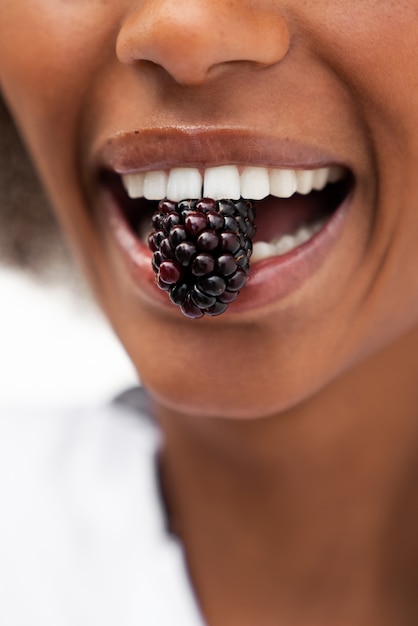 Bezpłatne zdjęcie widok z przodu uśmiechnięta kobieta jedząca jeżyny