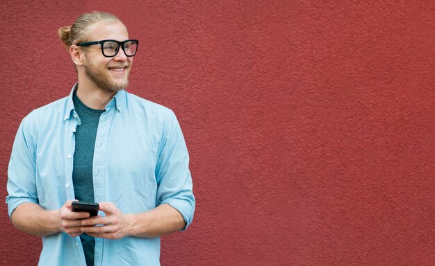 Widok z przodu uśmiechniętego mężczyzny trzymającego smartfon