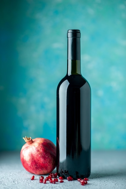 Bezpłatne zdjęcie widok z przodu wino granatowe na niebieskiej ścianie pić alkohol owocowy wino kwaśny kolor sok z baru restauracja