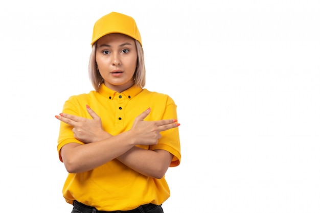 Widok z przodu żeński kurier w żółtej czapce żółtej koszuli i czarnych dżinsach stwarzających na białym tle usługi dziewczyna dostawy