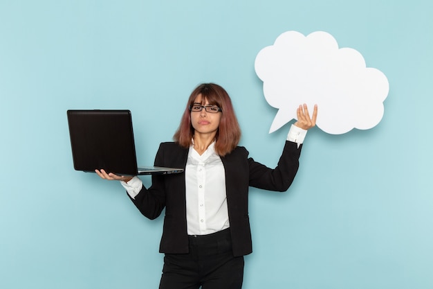 Bezpłatne zdjęcie widok z przodu żeński pracownik biurowy posiadający duży biały znak i laptop na niebieskiej powierzchni