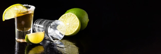 Widok z przodu złota tequila shot i limonka z kopiowaniem miejsca
