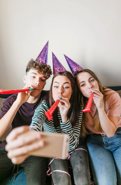 Bezpłatne zdjęcie widok z przodu znajomych dmuchanie rogi i robienie selfie