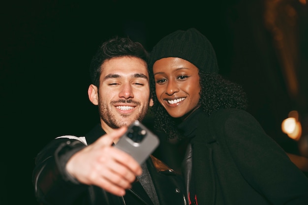 Bezpłatne zdjęcie widok z przodu znajomych robiących selfie w nocy