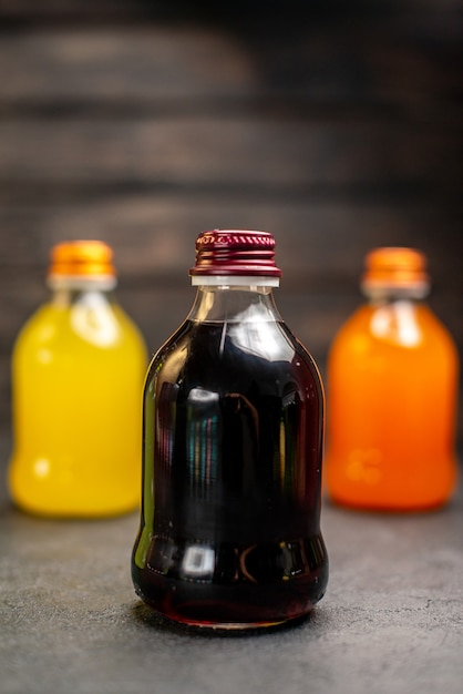 Bezpłatne zdjęcie widok z przodu żółte, czarne i pomarańczowe butelki z sokiem