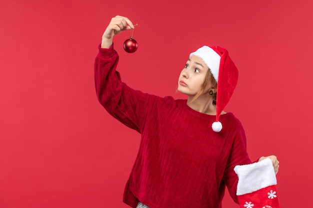 Widok z przodu zwykła kobieta trzymająca zabawki świąteczne, świąteczne czerwone wakacje