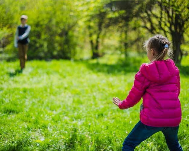 Widok z tyłu dziewczyna gra w parku