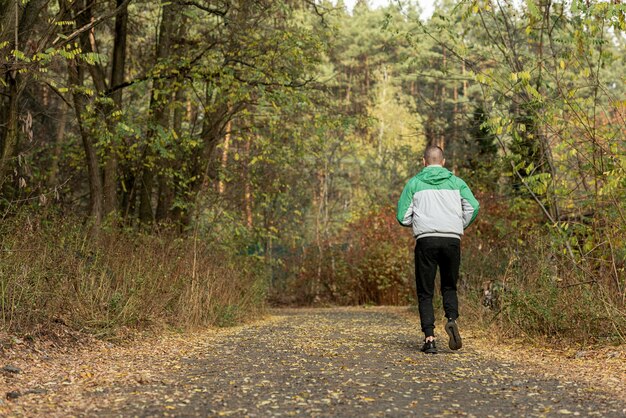 Widok z tyłu sportowy mężczyzna joggingu w przyrodzie