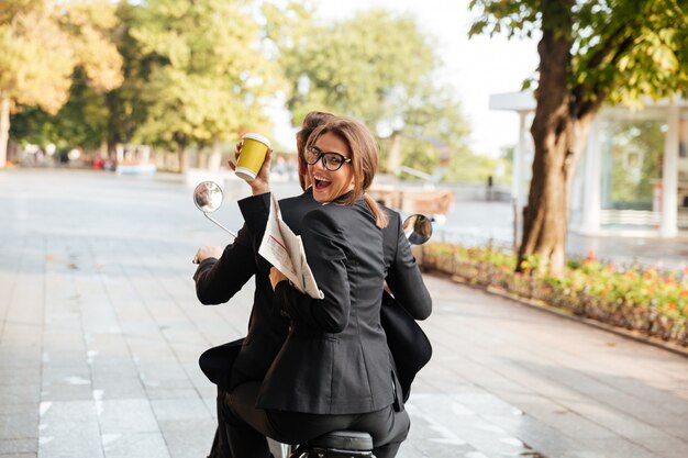 Widok zadowolonej eleganckiej pary z tyłu na nowoczesnym motocyklu