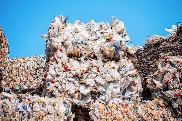 Wiele kostek skompresowanych plastikowych śmieci w pobliżu fabryki recyklingu odpadów na świeżym powietrzu