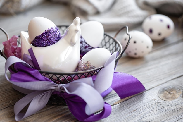 Wielkanocna kompozycja z jajkami ozdobionymi fioletowymi błyskami