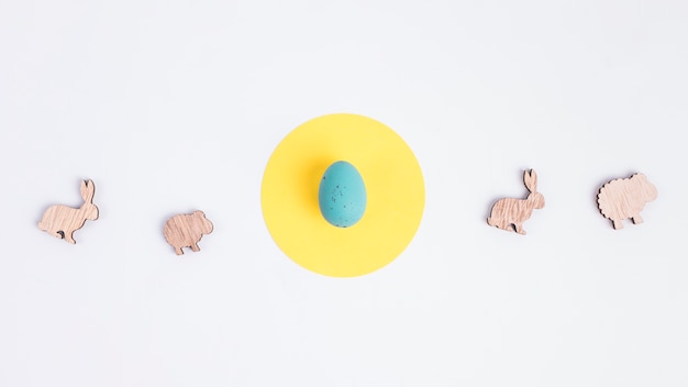 Bezpłatne zdjęcie wielkanocny jajko na żółtym okręgu między postaciami cakle i króliki