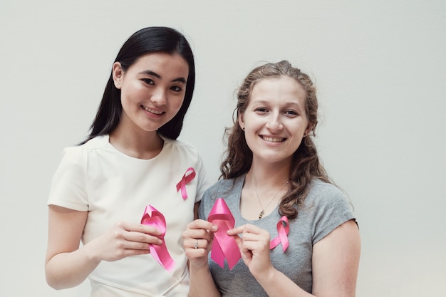 Wielokulturowe młode kobiety z różowymi wstążkami