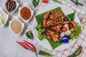 Bezpłatne zdjęcie wieprzowina nam tok ze smażonym chili, pomidorem, limonką, ogórkiem i świeżą papryką. tajskie jedzenie.