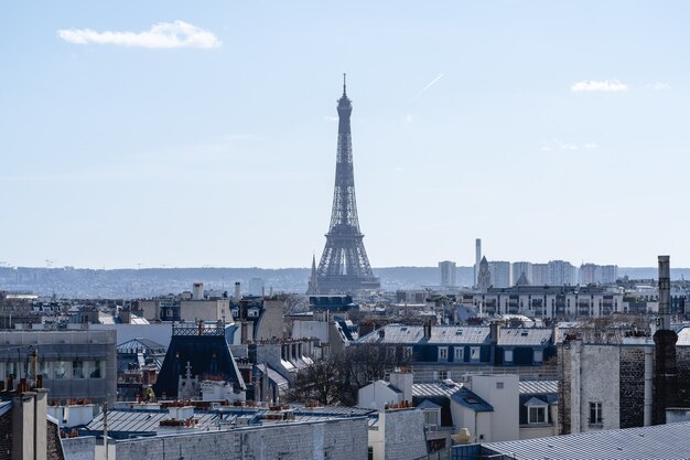 Wieża Eiffla otoczona budynkami w słońcu w Paryżu we Francji