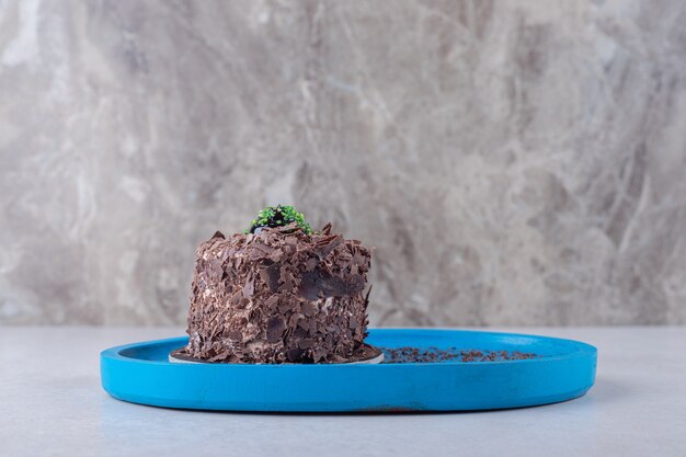 Wilgotny biszkopt czekoladowy brownie na drewnianym talerzu na marmurowym stole.