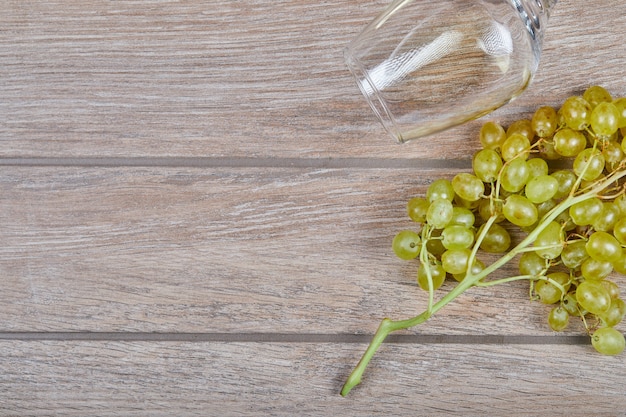 Winogrona i kieliszek do wina na powierzchni drewnianych