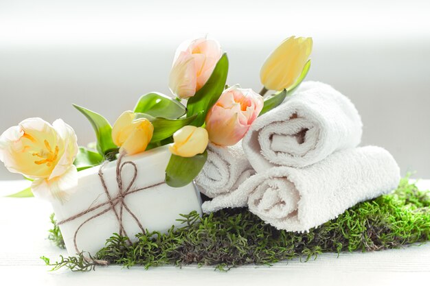 Wiosenna kompozycja Spa z elementami pielęgnacji ciała ze świeżymi tulipanami na jasnym tle, uroda i zdrowie.