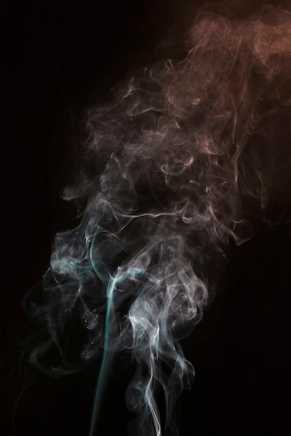 Bezpłatne zdjęcie wir białego i turkusowego dymu na czarnym tle ciemności