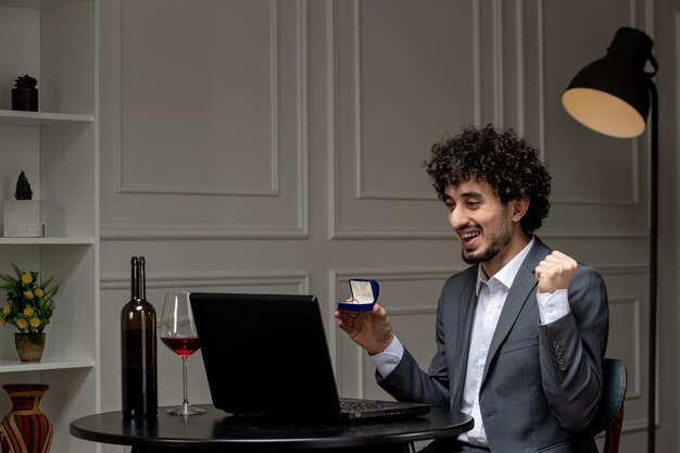 Wirtualna miłość przystojny śliczny facet w garniturze z winem na odległość komputerowa randka oświadczająca się pięścią w górę