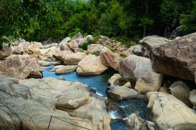 Woda płynąca pośrodku skał na klifie wodospadów Ba Ho w Wietnamie